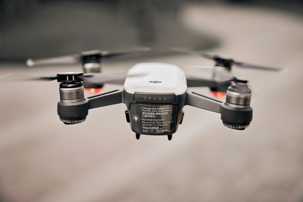 Close-up of a modern drone flying outdoors, showcasing advanced technology and propellers.